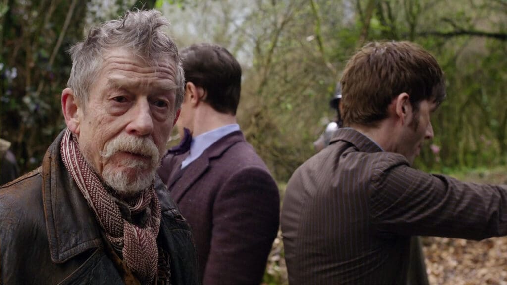The War Doctor, looking amused. Ten and Eleven in the background