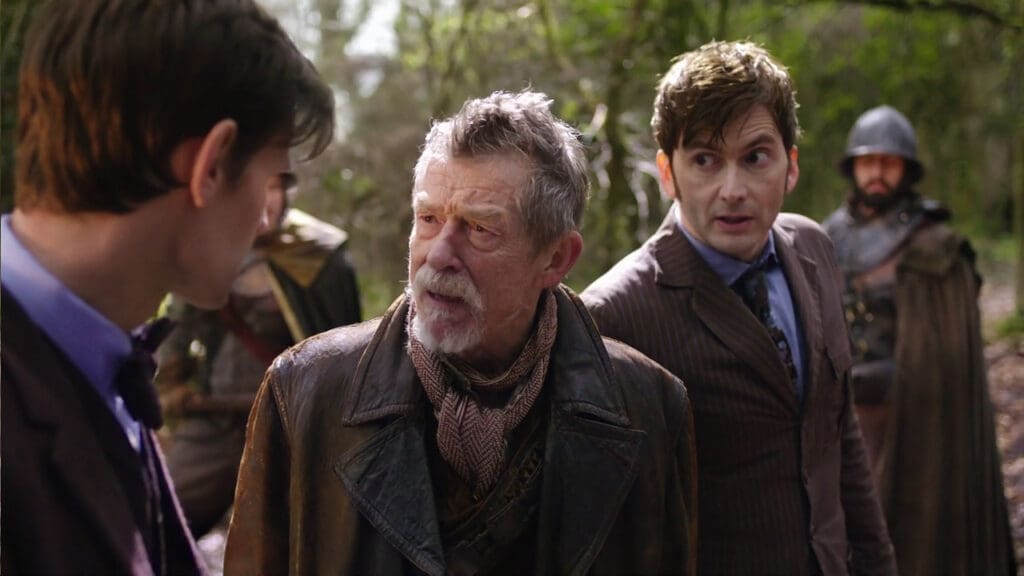 The War Doctor, looking flabbergasted at Eleven, Ten in the background pretending not to understand