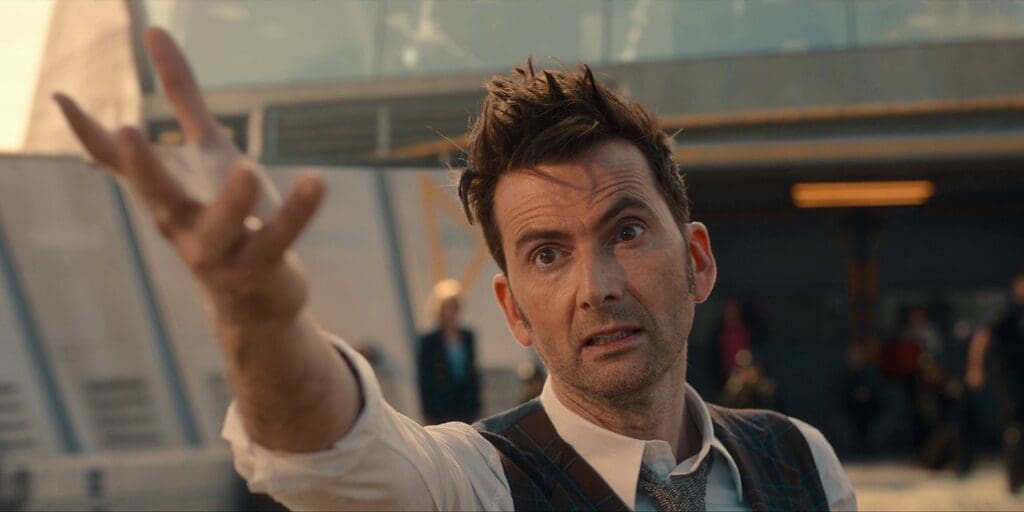 The 14th Doctor extending an arm out to the Toymaker