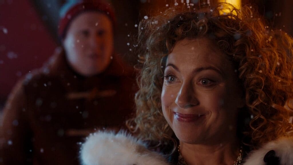 River Song, smiling. Nardole in the background.