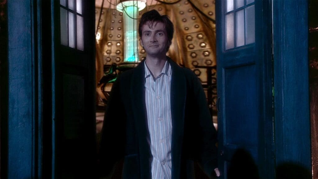 The Doctor, in a bath robe and pyjamas, standing in the TARDIS doorway.