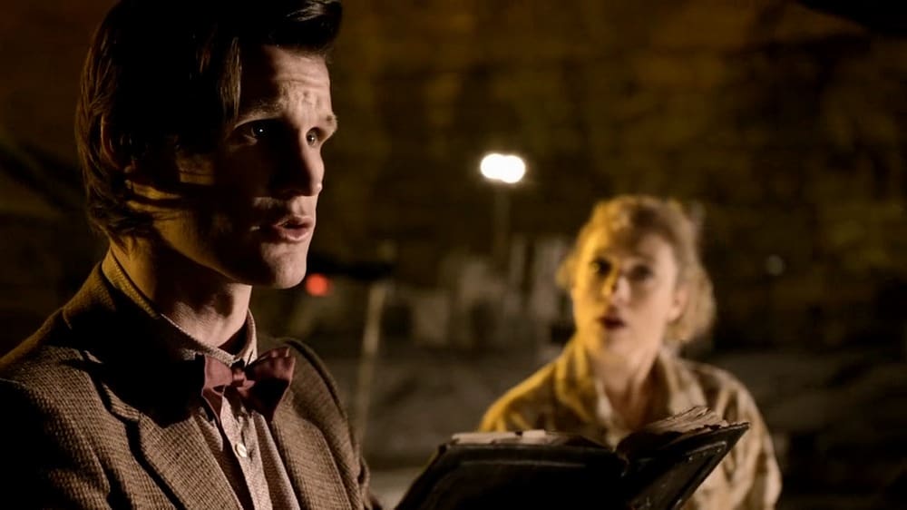 The Doctor, reading the book about the Angels, with River in the background