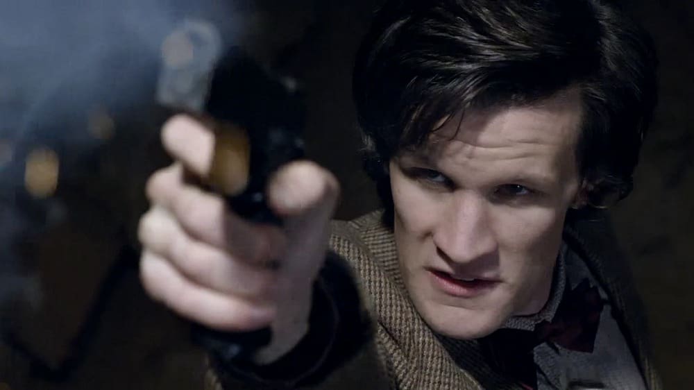 The Doctor, firing a gun up in the air