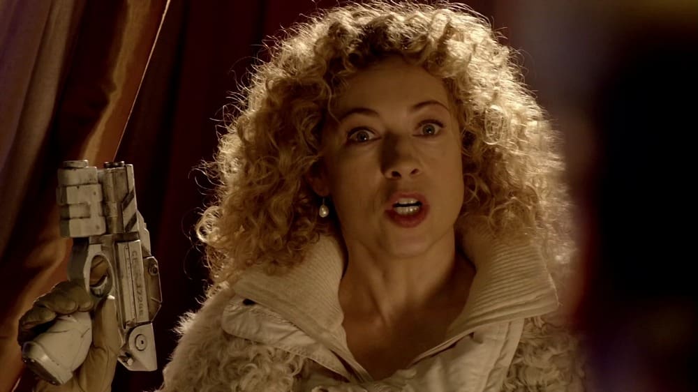River Song, holding up her gun