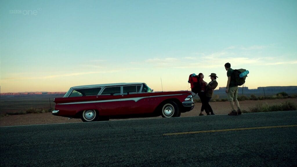 Wide angle shot of The Doctor hugging Amy, Rory is there, in the desert in USA with a car.