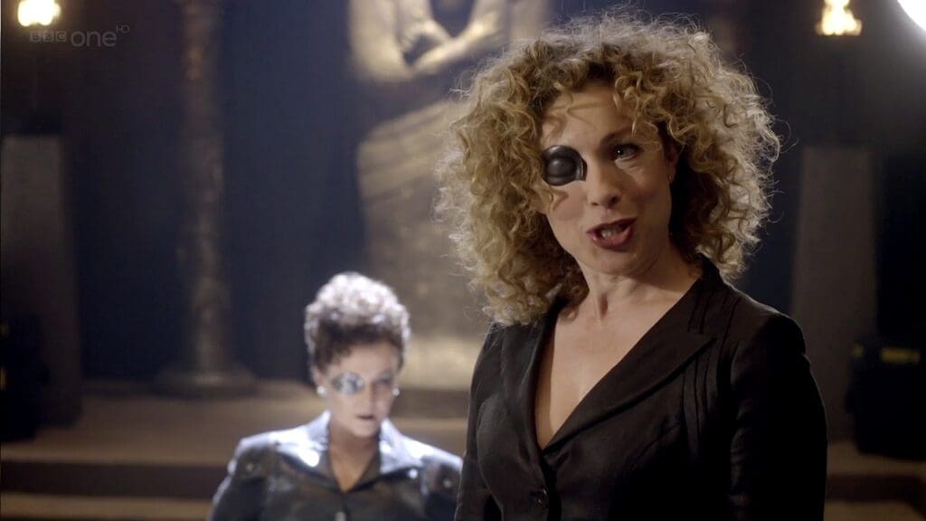 River Song, wearing an eye patch. Madame Kovarian is behind her.